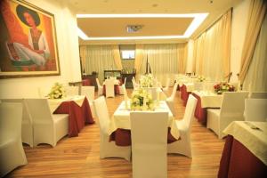 a dining room with white tables and white chairs at Hotel Miracle in Addis Ababa