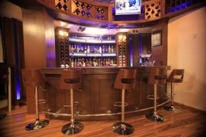 a bar with brown bar stools in a room at Hotel Miracle in Addis Ababa