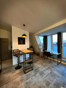 a living room with a table and chairs and windows at Talgarten Penthouse 1 in Erfurt +1 photo