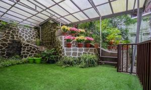 um jardim com pérgola e vasos de plantas em Treebo Tryst Tempo Heritage Spa & Resort em Gangtok