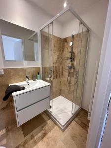 La salle de bains est pourvue d'une douche et d'un lavabo. dans l'établissement Résidence Terminus - appartements, à Sainte-Maxime