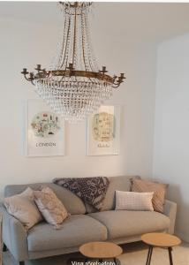 a chandelier hanging over a couch in a living room at Centrum lägenhet in Skövde