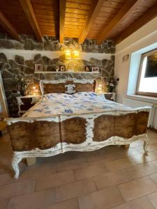 Cama grande en habitación con pared de piedra en Casa Samuela 