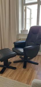 2 sillas sentadas en una sala de estar junto a una ventana en Centrum lägenhet, en Skövde