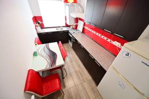 a kitchen with red chairs and a table and a counter at Shine in Sibiu in Şelimbăr