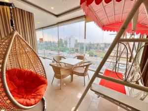チャンディーガルにあるHotel Pearl Grand, Zirakpur - Top Rated & Most Awarded Property in Tricityのハンモック、テーブル、椅子が備わる客室です。