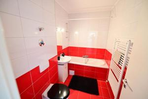 a red and white bathroom with a toilet and a sink at Shine in Sibiu in Şelimbăr