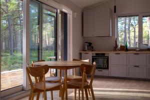 uma cozinha com uma mesa de madeira e cadeiras em frente a uma janela em Rooslepa seaside getaway em Rooslepa