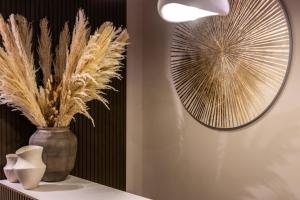 a table with a vase and a mirror on a wall at Duomo Collection in Milan