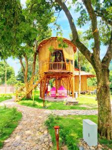 a tree house with a playground in a park at Little Bee in Luong Son