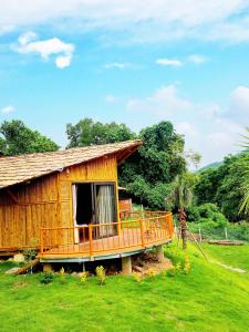ein Haus mit einer großen Terrasse im Gras in der Unterkunft Little Bee in Luong Son