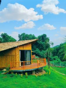 ein Haus mit einer großen Terrasse auf einem Feld in der Unterkunft Little Bee in Luong Son