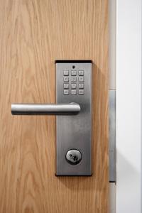 a metal door with a handle on a wooden door at Serviced Apartments Kuohu Kangasala by UHANDA in Kangasala