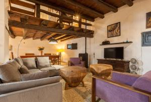 a living room with a couch and a tv at Masia del siglo xvi in Vallbona