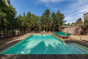 Vallbona的住宿－Masia del siglo xvi，一个带蓝色椅子和树木的游泳池