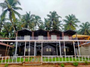 a house on the beach with palm trees in the background at Agonda Paradise in Agonda