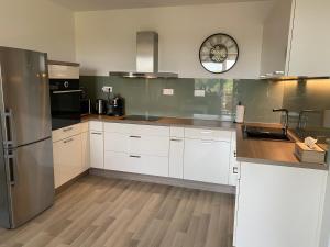 a kitchen with white cabinets and a stainless steel refrigerator at Self check in with parking included in Bratislava