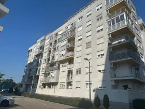 a tall white apartment building with a parking lot at Pia Apartment -SelfCheckIn-free parking in Zagreb