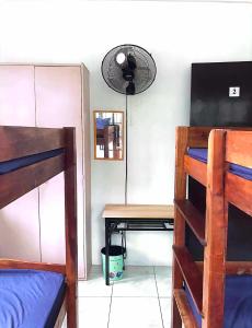 a room with bunk beds and a desk with a fan at Estrelle Orange House - Backpackers Hub in Puerto Princesa City