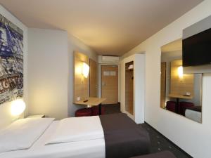 a hotel room with a bed and a desk at B&B HOTEL Berlin-Alexanderplatz in Berlin
