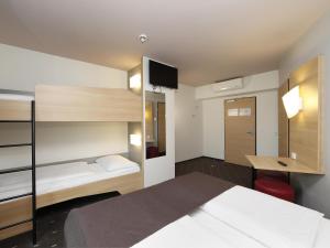 柏林的住宿－B&B HOTEL Berlin-Alexanderplatz，一间卧室配有一张床、一张桌子和一张双层床。