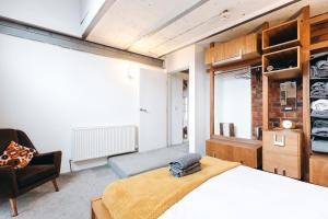 a bedroom with a bed and a chair in a room at Loftnine9 in Liverpool