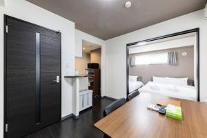 a hotel room with a bed and a table and a bedroom at Essence in Sapporo