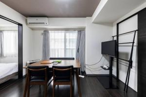 a room with a table and chairs and a bed at Essence in Sapporo