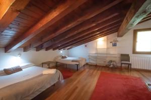 AiaにあるOribarzar - Vivienda acogedora en plena naturalezaのベッドルーム1室(ベッド2台、赤い敷物付)