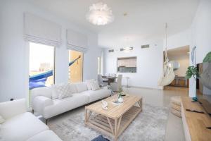 a living room with a white couch and a table at Contemporary Living by The Sea & 2BD & New Listing in Ras al Khaimah