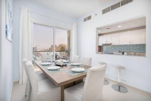 a kitchen and dining room with a table and chairs at Contemporary Living by The Sea & 2BD & New Listing in Ras al Khaimah