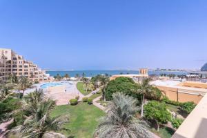 an aerial view of a resort with palm trees and the ocean at Contemporary Living by The Sea & 2BD & New Listing in Ras al Khaimah