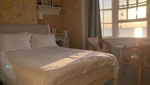 1 dormitorio con cama, ventana y mesa en Whitecliff Guest House, en Weymouth