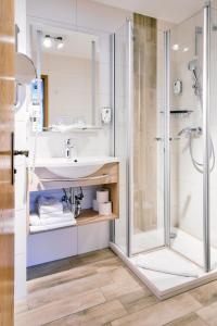 ein Badezimmer mit Waschbecken und Dusche in der Unterkunft Blochums Gasthof Hirsch in Marktoberdorf