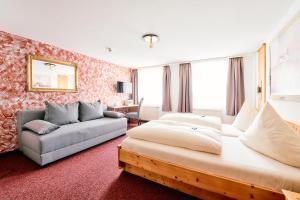 ein Hotelzimmer mit einem Bett und einer Couch in der Unterkunft Blochums Gasthof Hirsch in Marktoberdorf