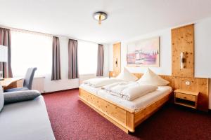 ein Schlafzimmer mit einem großen Bett mit weißen Kissen in der Unterkunft Blochums Gasthof Hirsch in Marktoberdorf