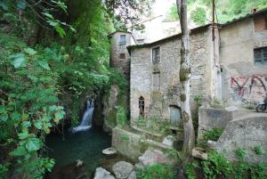 a waterfall in the middle of a river next to a building at La Stagione dell'Arte in Camaiore