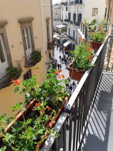 a balcony with plants and people walking down a street at ApartHotel Antica Repubblica in Amalfi center at 100mt from the sea with payment parking in Amalfi