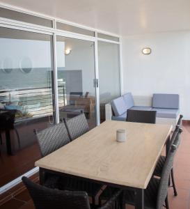 a table and chairs in a room with a view of the ocean at Palm Cove - 16 Chakas Cove, Literally on the Beach in Ballito