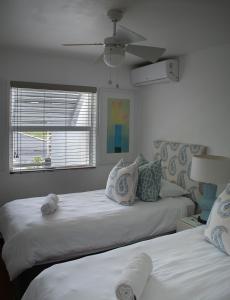 a bedroom with two beds and a window at Palm Cove - 16 Chakas Cove, Literally on the Beach in Ballito
