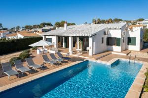 a villa with a swimming pool in front of a house at Villa Michaela in Sant Lluis