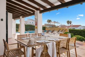 Une table à manger et des chaises sont disponibles sur la terrasse. dans l'établissement Villa Michaela, à Sant Lluis