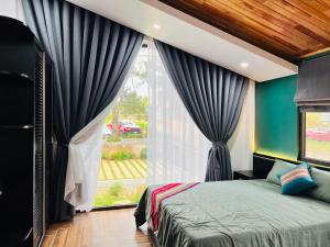 a bedroom with a bed and a large window at Eva Măng Đen Homestay in Kon Von Kla