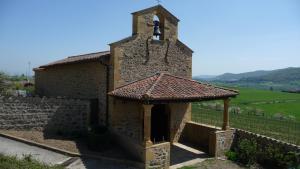 a small stone church with a bell tower on a hill at Petite maison dans le beaujolais in Les Olmes