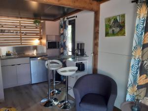 - une cuisine avec une table et des chaises dans la chambre dans l'établissement Camping Etang Du Camp, à Sénergues