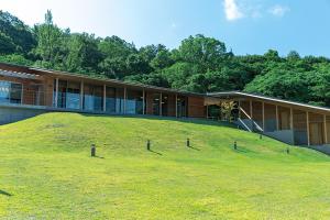a building with a grassy hill in front of it at Teshima ESPOIR PARK in Ieura