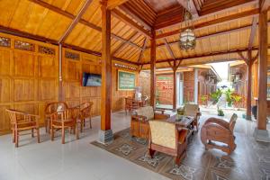 una sala da pranzo con pareti e tavoli in legno e sedie di OYO 92606 Djoglo Boto Homestay Syariah a Yogyakarta
