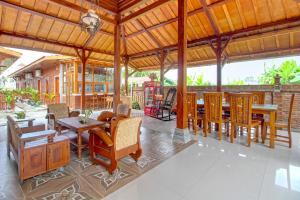 een eetkamer met houten tafels en stoelen bij OYO 92606 Djoglo Boto Homestay Syariah in Yogyakarta