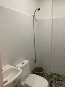 La salle de bains blanche est pourvue de toilettes et d'un lavabo. dans l'établissement Dapitan Travellers Inn, à Dapitan