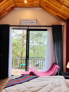 a bedroom with a bed and a large window at Eva Măng Đen Homestay in Kon Von Kla